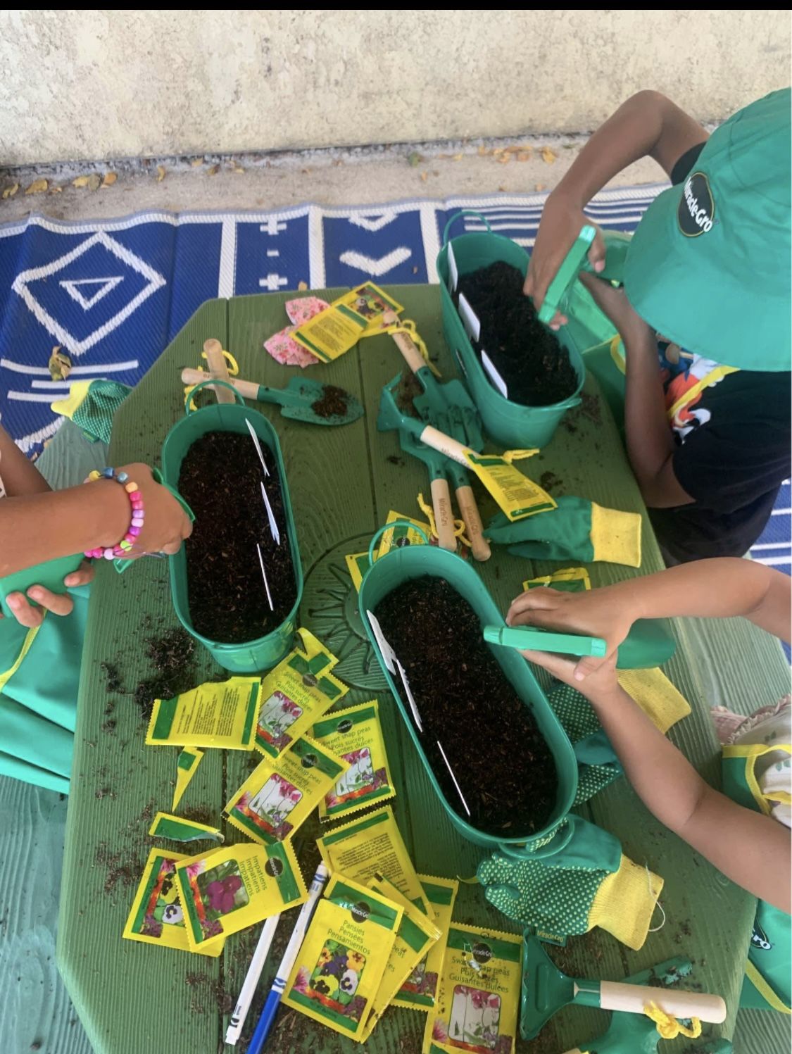 Small hands planting seeds in pots